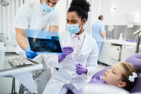 A photo of the physician chatting with her staff while treating a patient