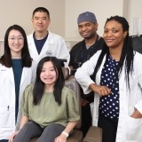 Clinical trial participant MinFen Lydia Foreman (seated) posed with members of NIDCR’s clinical team (from left to right), physician assistant Rachelle Chung, Drs. Ling Ye and Ayodeji Awopegba, and research nurse Danielle Elangue, at a recent visit.